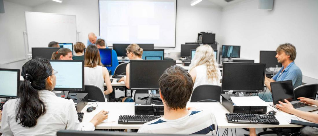 Students working at computers in a bright modern classroom